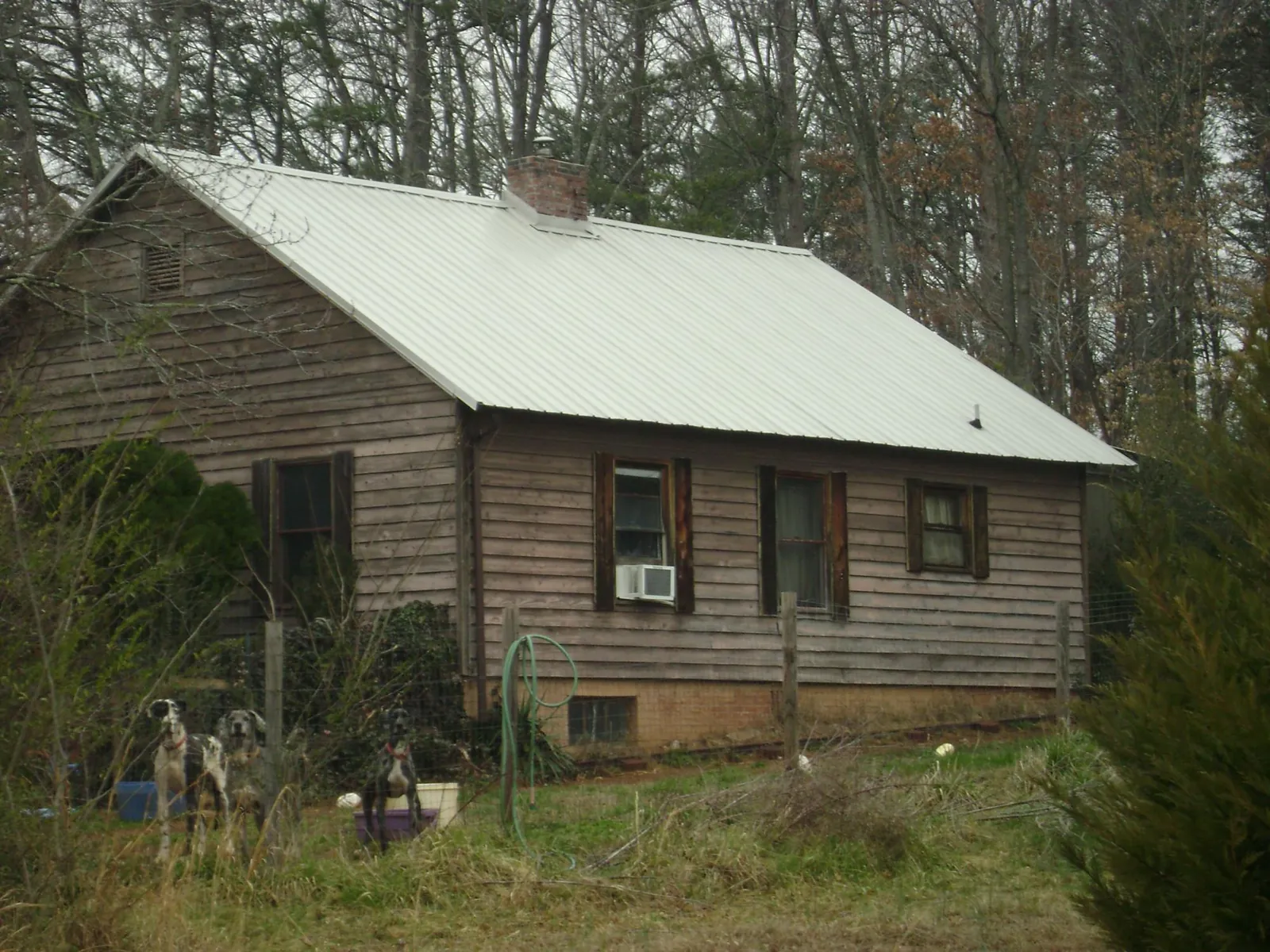 White metal roof on an old wood sided farmhouse, from a Metal Roof Installation job in Boyce